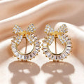 Gold bow stud earrings by Yoshan, view 2